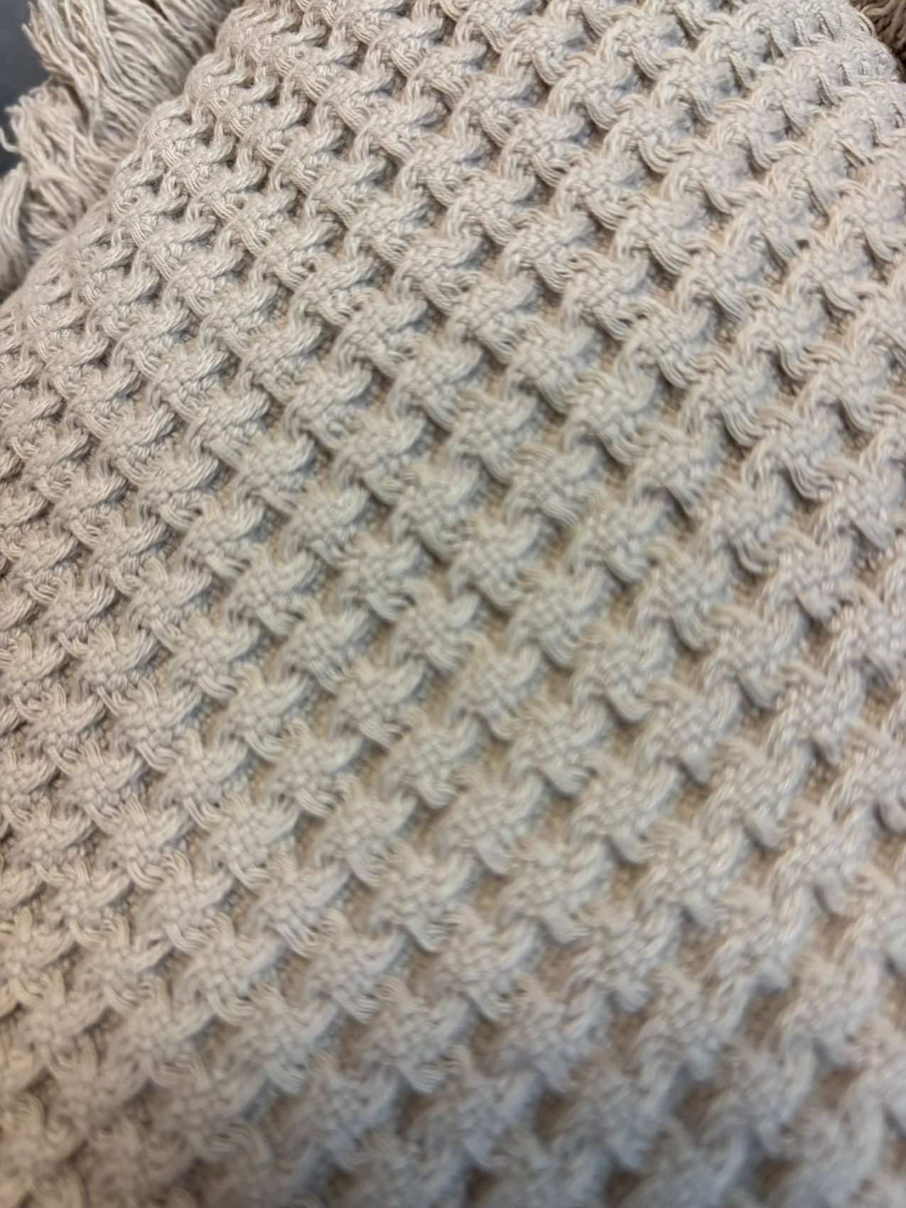 Coixí decoratiu gris amb textura waffle i serrells – Funda i farciment inclosos